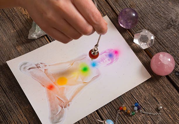 chakras-illustrated-over-human-body-with-natural-crystals-and-pendulum